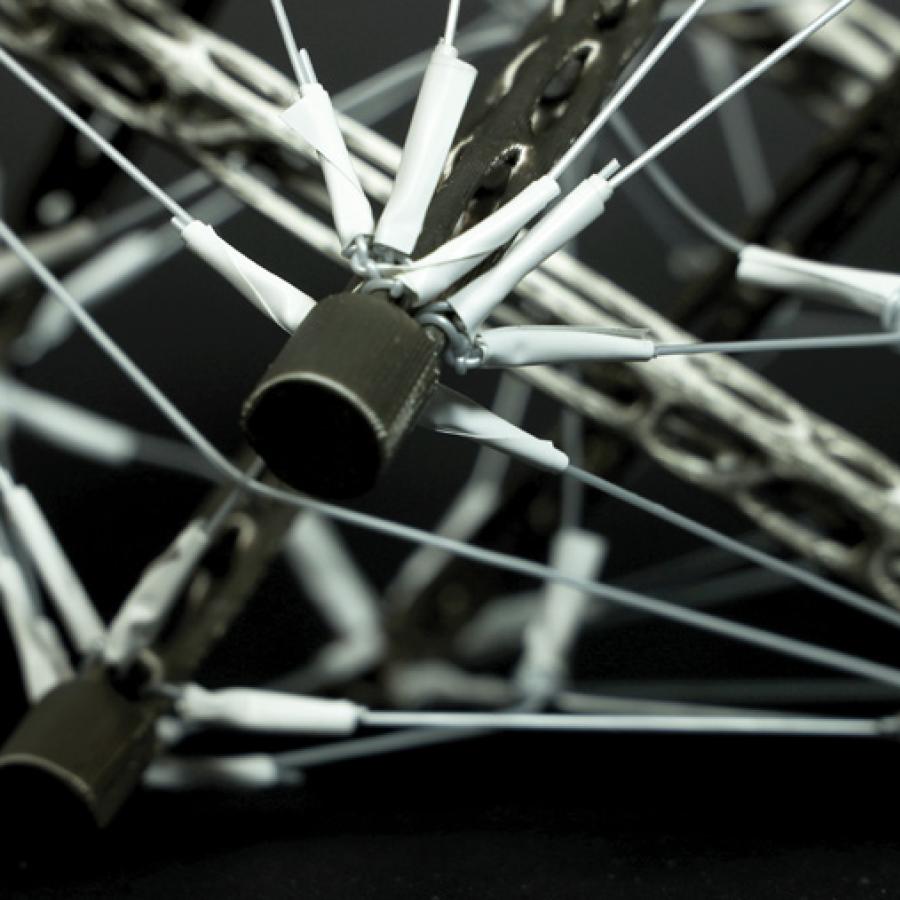 Zoomed-in view of a solid geometric structrure formed by multiple metal rods and wires tensed together. 